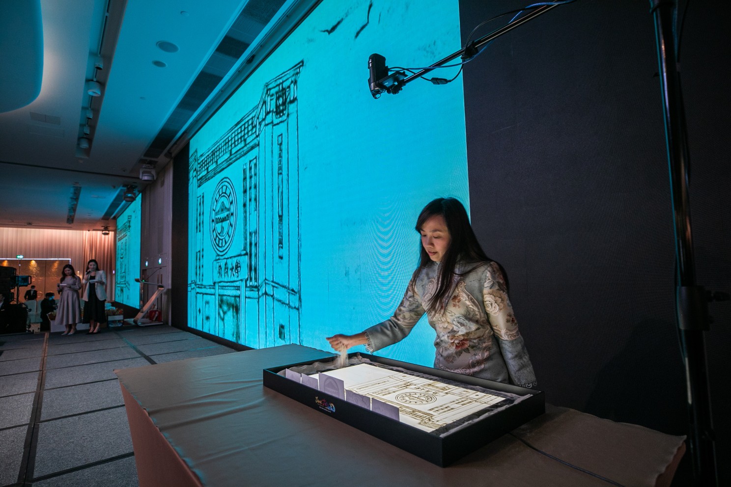 The event also features a sand painting performance by renowned Hong Kong Sand Painting Artist Ms Edith Wu, walking the audience through Lingnan University's rich history and milestones on a artistic sand painting journey.
