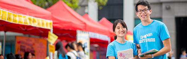 students smiling in front of booth